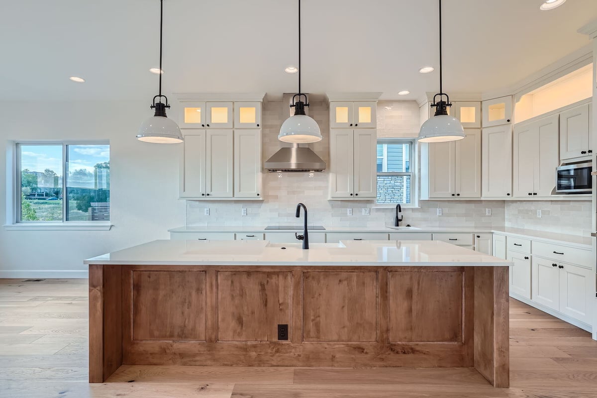 Custom kitchen with pendant lighting, white cabinets, and a wooden island, Sheffield Homes, Denver, CO