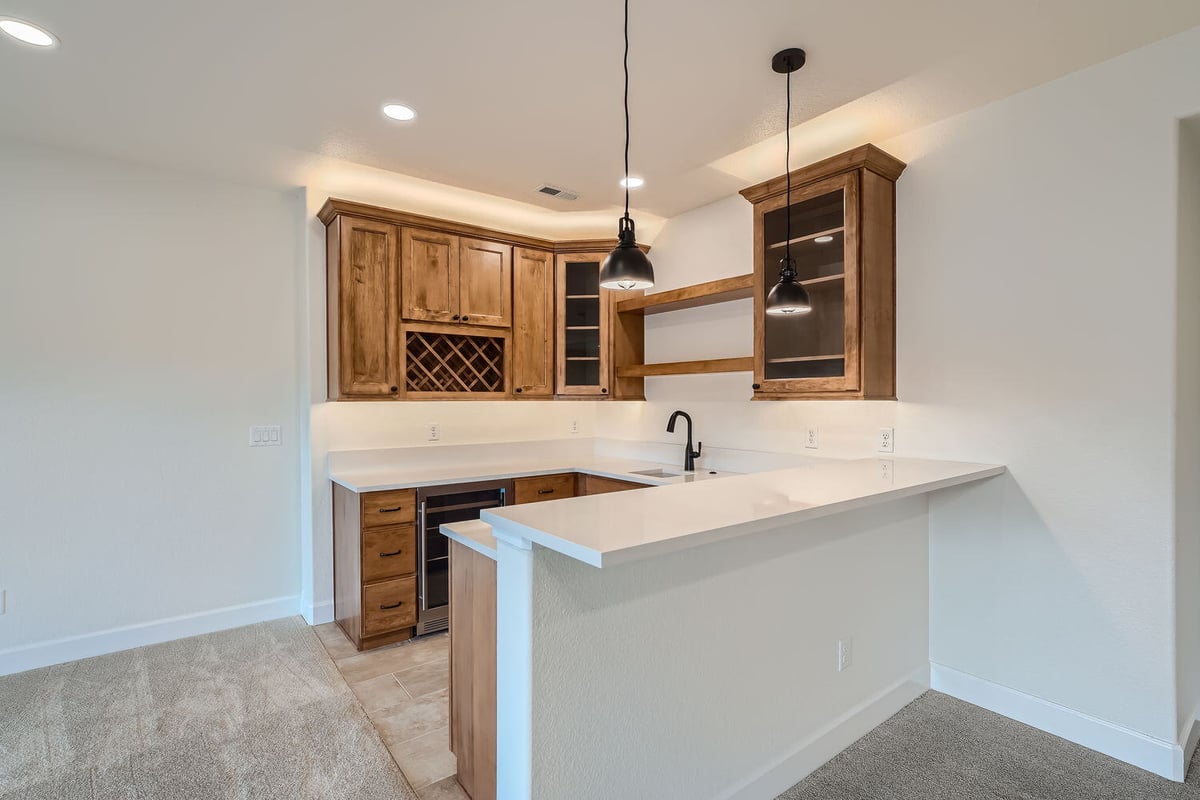 Elegant lower-level wet bar with wood cabinetry in a custom home by Sheffield Homes, Denver, CO