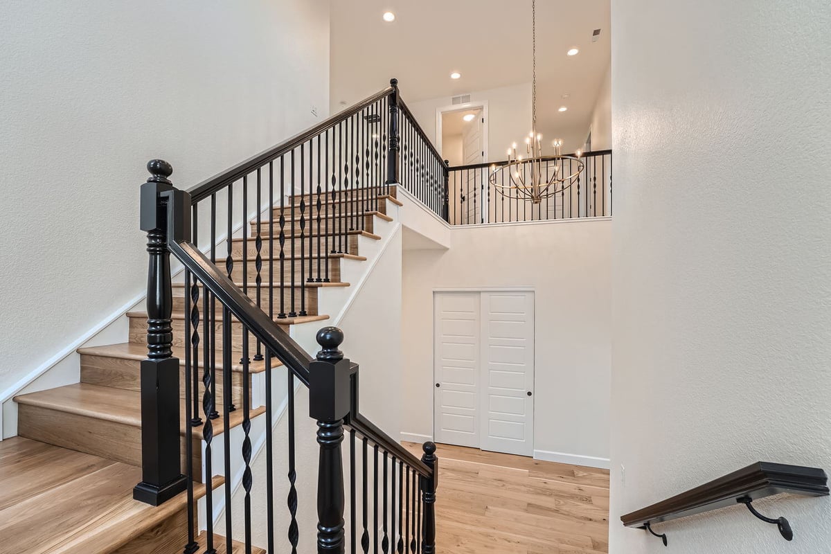 Elegant staircase with iron railings and chandelier, Sheffield Homes, Denver, CO