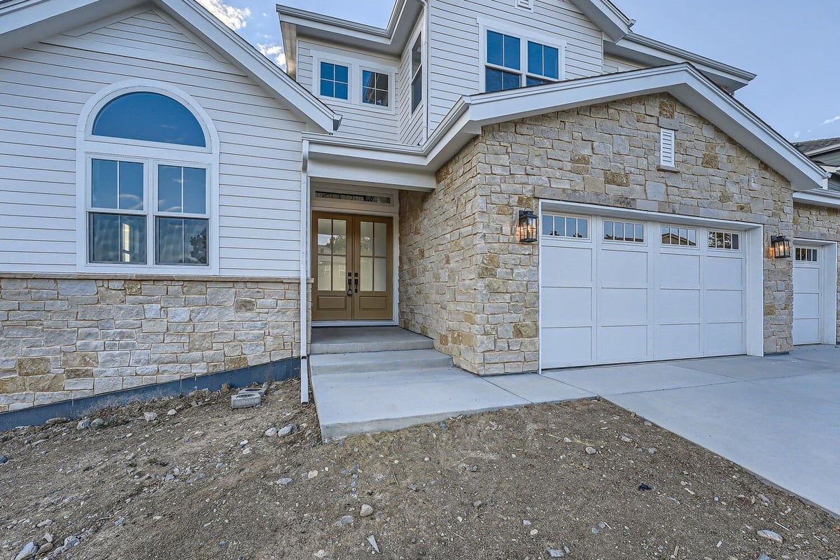 Front entryway of a custom home by Sheffield Homes in Denver, CO, with a stone facade and inviting double doors