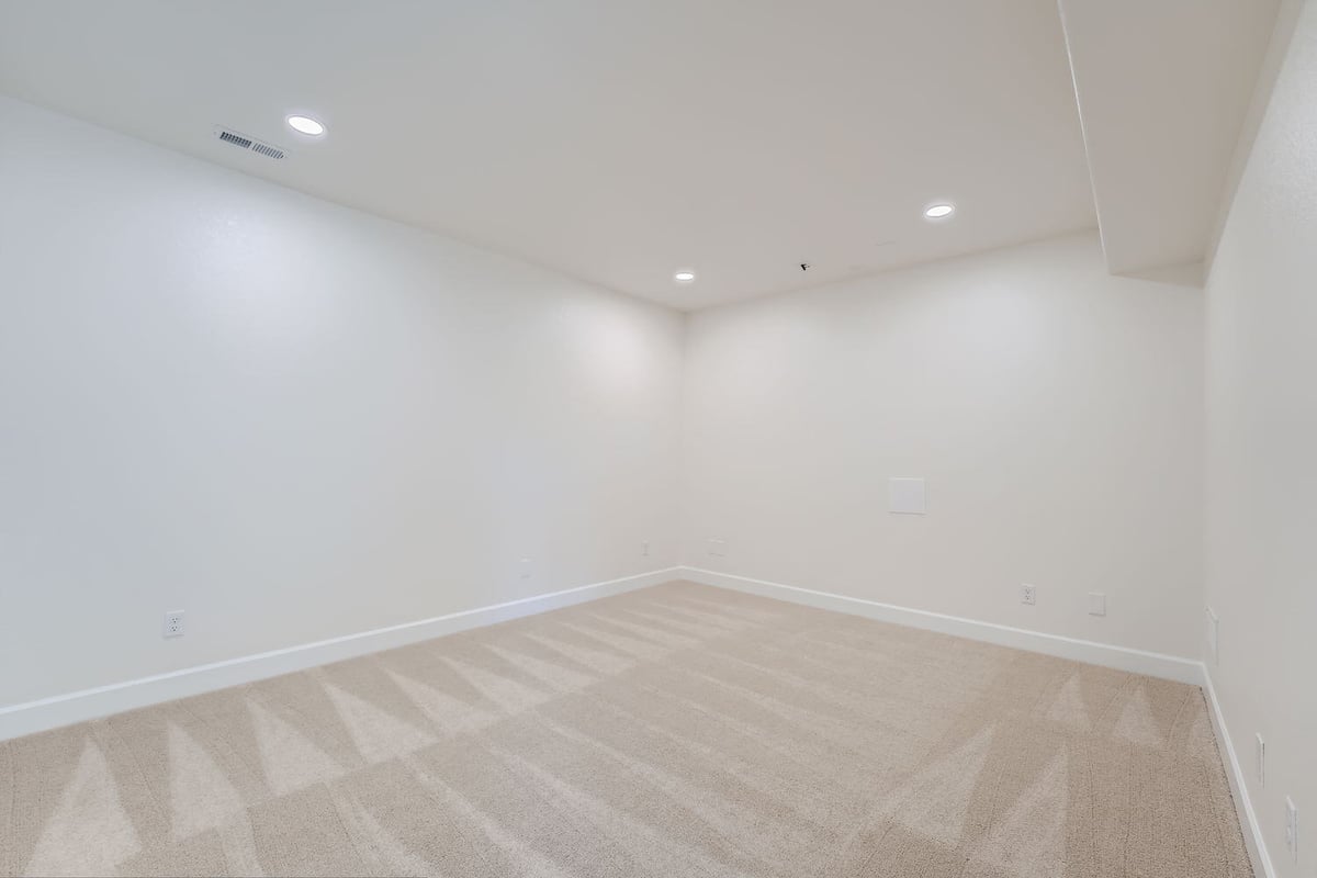Minimalist lower-level room with fresh carpeting, Sheffield Homes custom home, Denver, CO