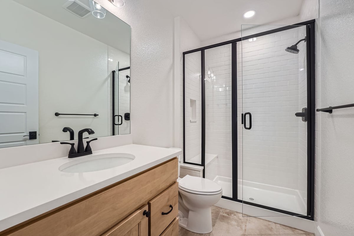 Modern lower-level bathroom with glass shower in a Sheffield Homes custom home, Denver, CO