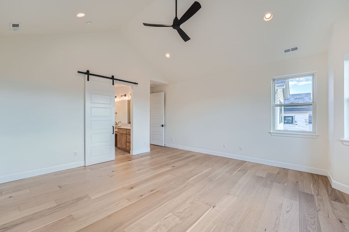 Primary bedroom with ceiling fan and scenic window view, Sheffield Homes, Denver, CO