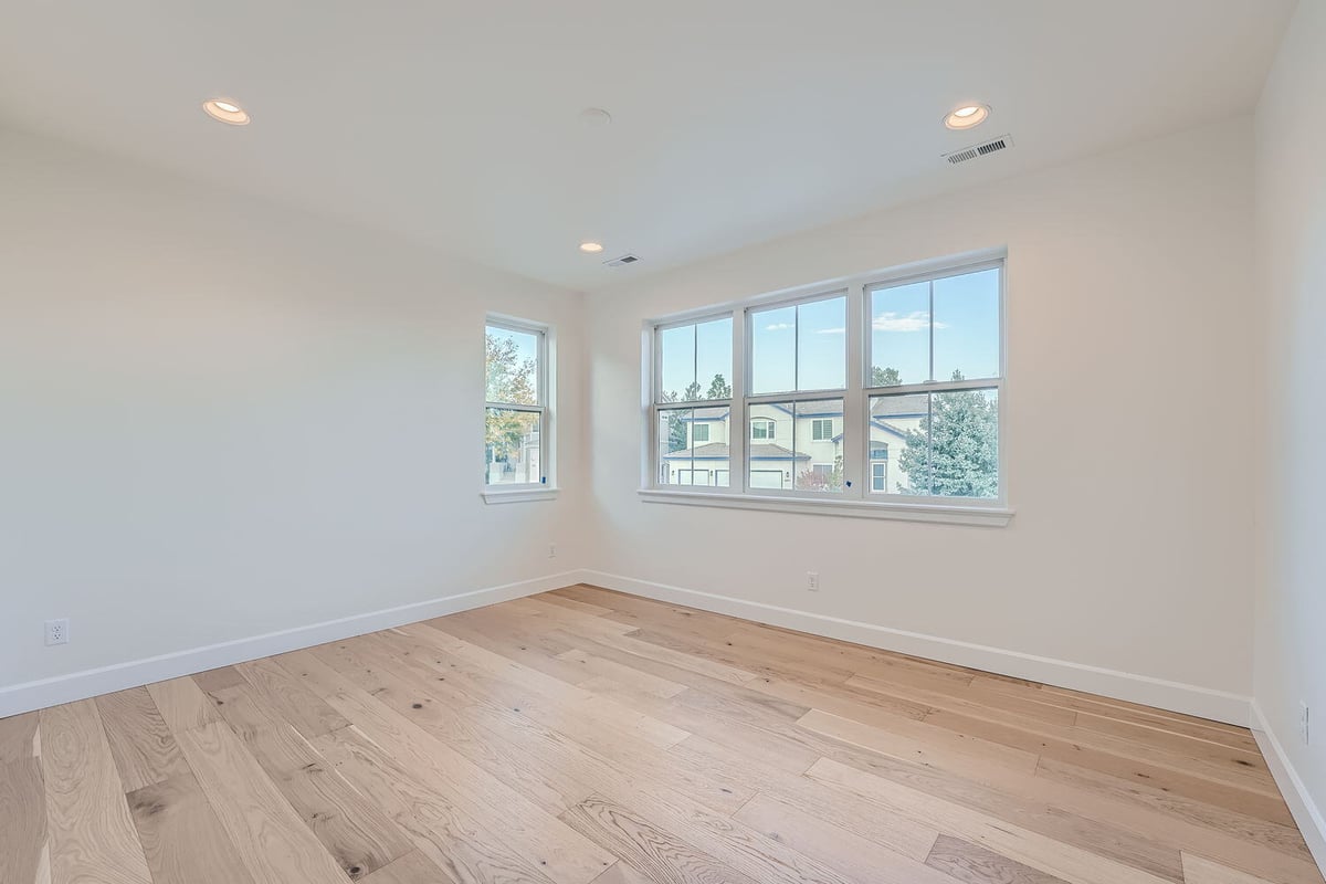 Spacious bedroom with light wood flooring and large windows, Sheffield Homes, Denver, CO
