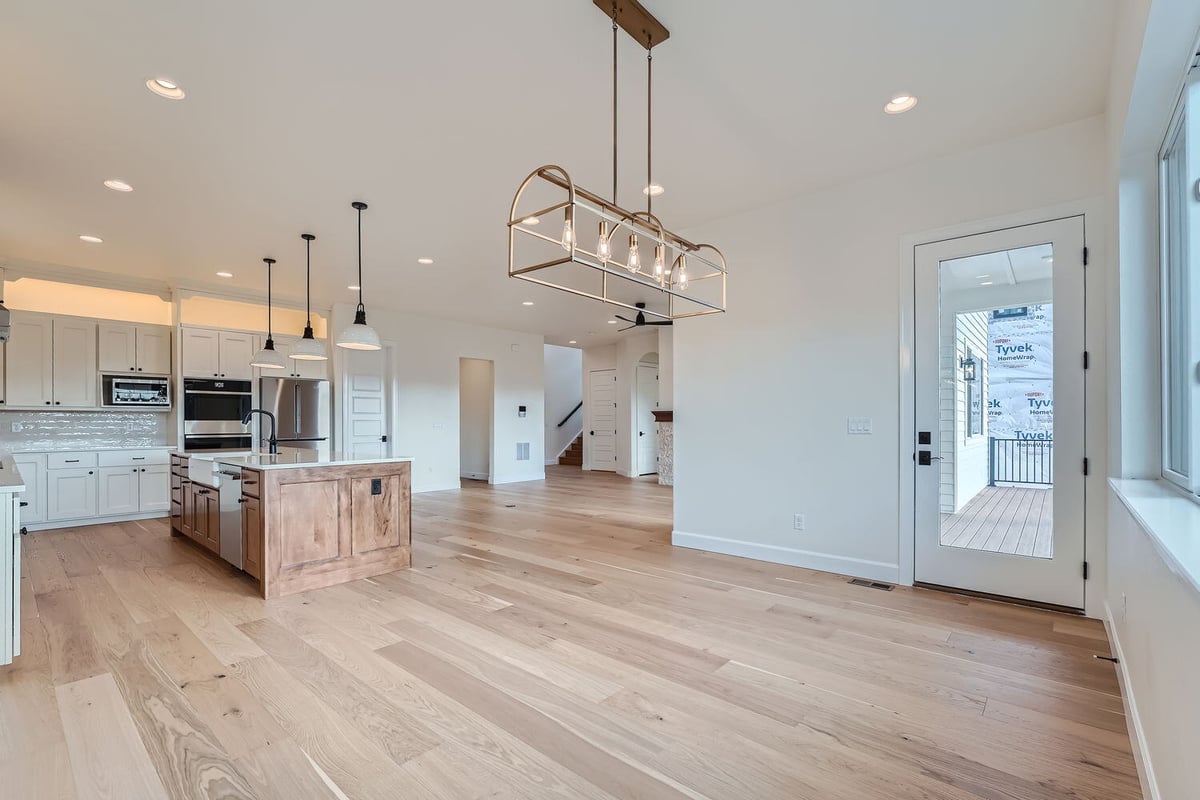 Spacious dining room in a Sheffield Homes custom home in Denver, CO, with large windows and modern chandelier