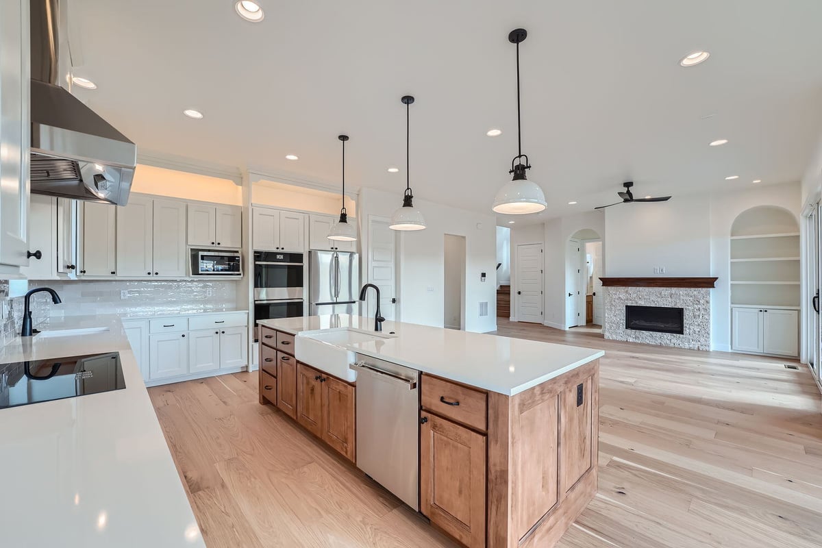 Spacious kitchen in a Sheffield Homes custom home in Denver, CO, with an island and modern lighting fixtures