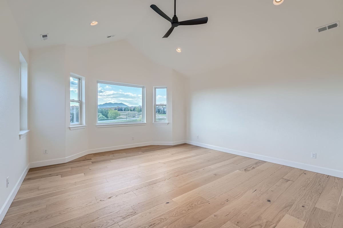 Spacious primary bedroom with hardwood floors and large windows, Sheffield Homes, Denver, CO