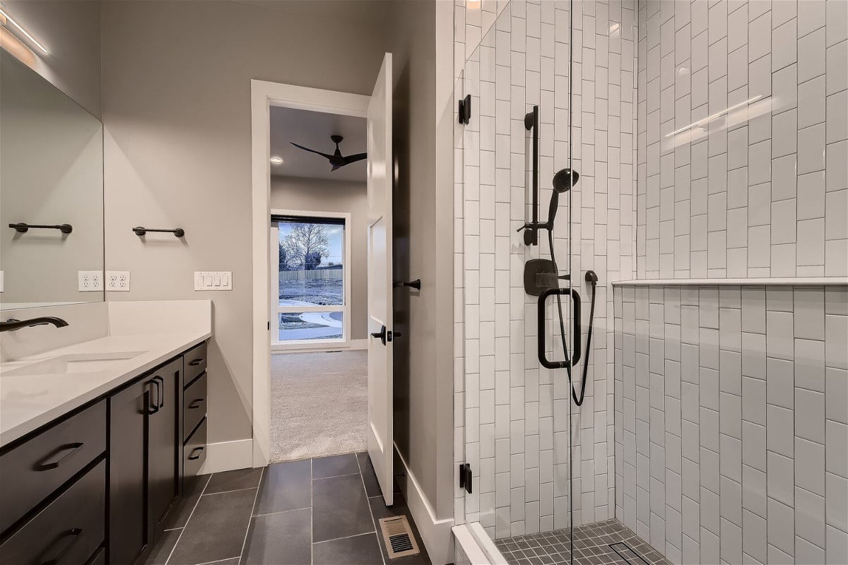 Bathroom with clean lines and a white-tiled shower in a custom home by Sheffield Homes, Denver, CO