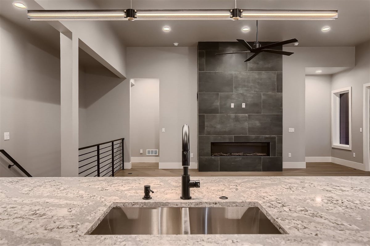 Close-up of kitchen sink and faucet in a custom home by Sheffield Homes, Denver, CO, showcasing marble countertop