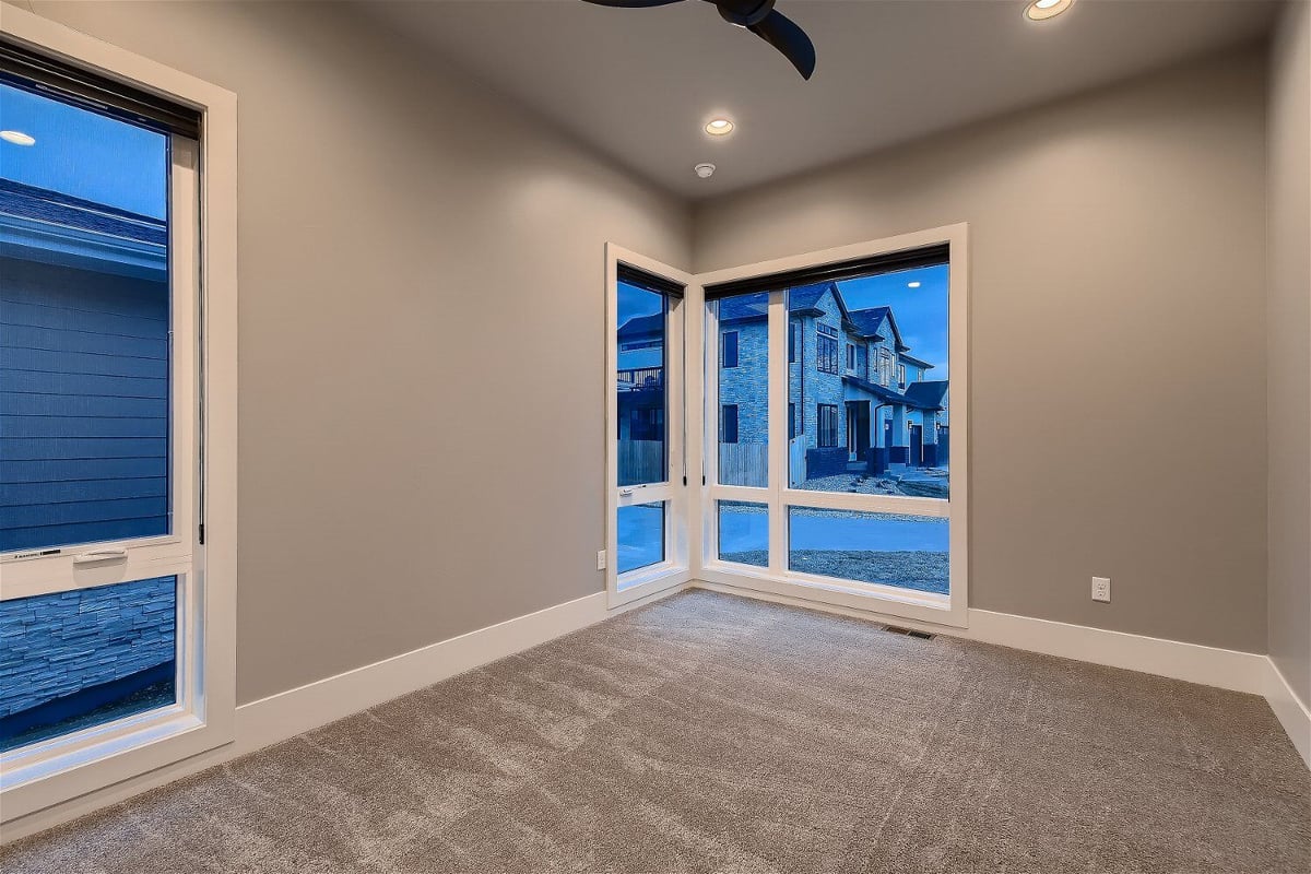 Cozy bedroom with large corner windows in a Sheffield Homes custom-built house, Denver, CO