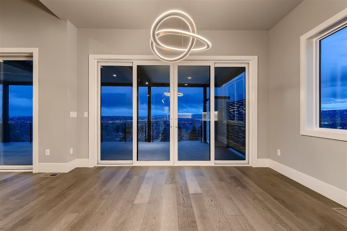 Dining room in a Sheffield Homes custom home in Denver, CO, with expansive sliding doors opening to a scenic view