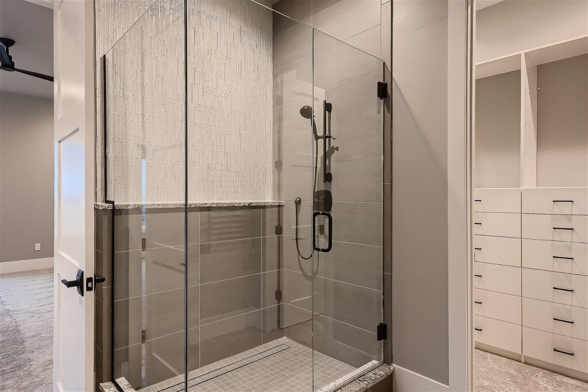 Elegant walk-in shower with floor-to-ceiling tiles in the primary bathroom of a custom Sheffield Homes build, Denver, CO