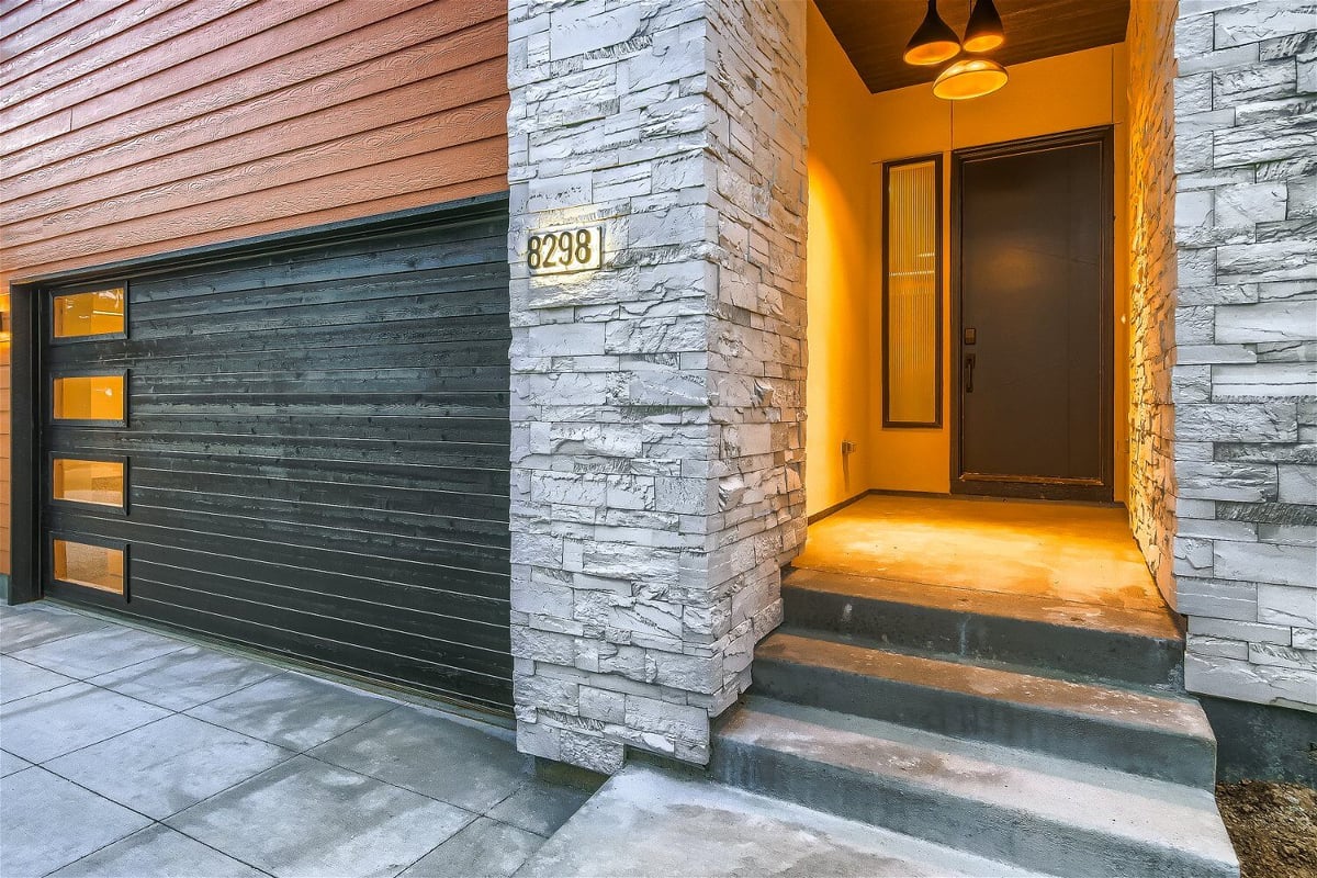 Front entryway of a modern Sheffield Homes custom-built home in Denver, CO, with stone accents and warm lighting