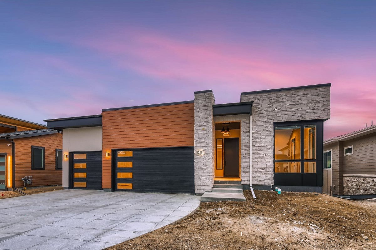 Front exterior of a modern custom home by Sheffield Homes in Denver, CO, featuring sleek architectural lines at dusk