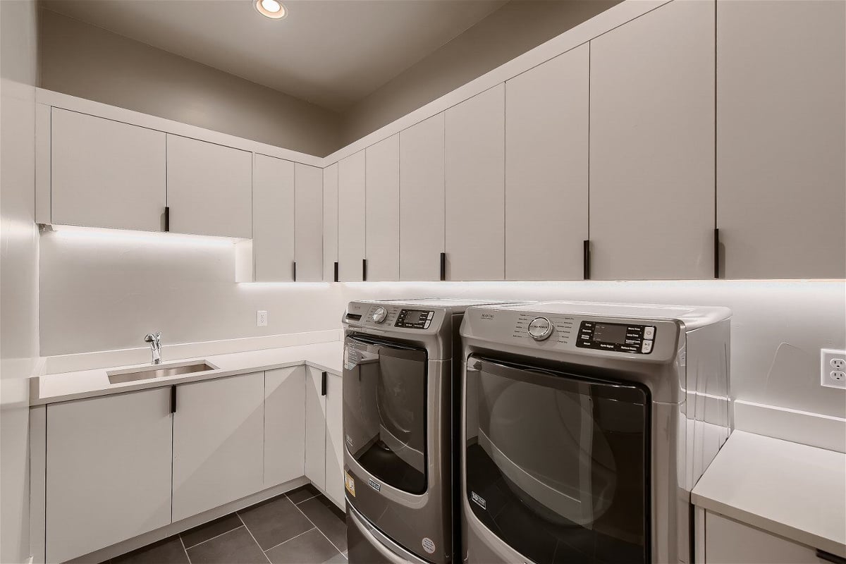Modern laundry room with ample cabinetry in Sheffield Homes custom home, Denver, CO