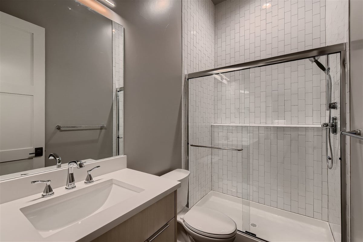 Modern lower-level bathroom with glass shower in Sheffield Homes custom home, Denver, CO