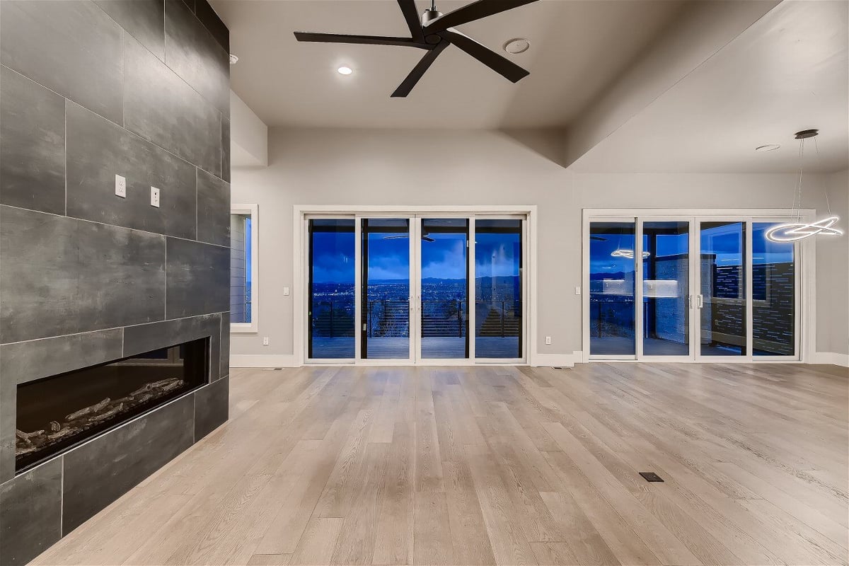 Spacious living room with large windows overlooking Denver cityscape, designed by Sheffield Homes