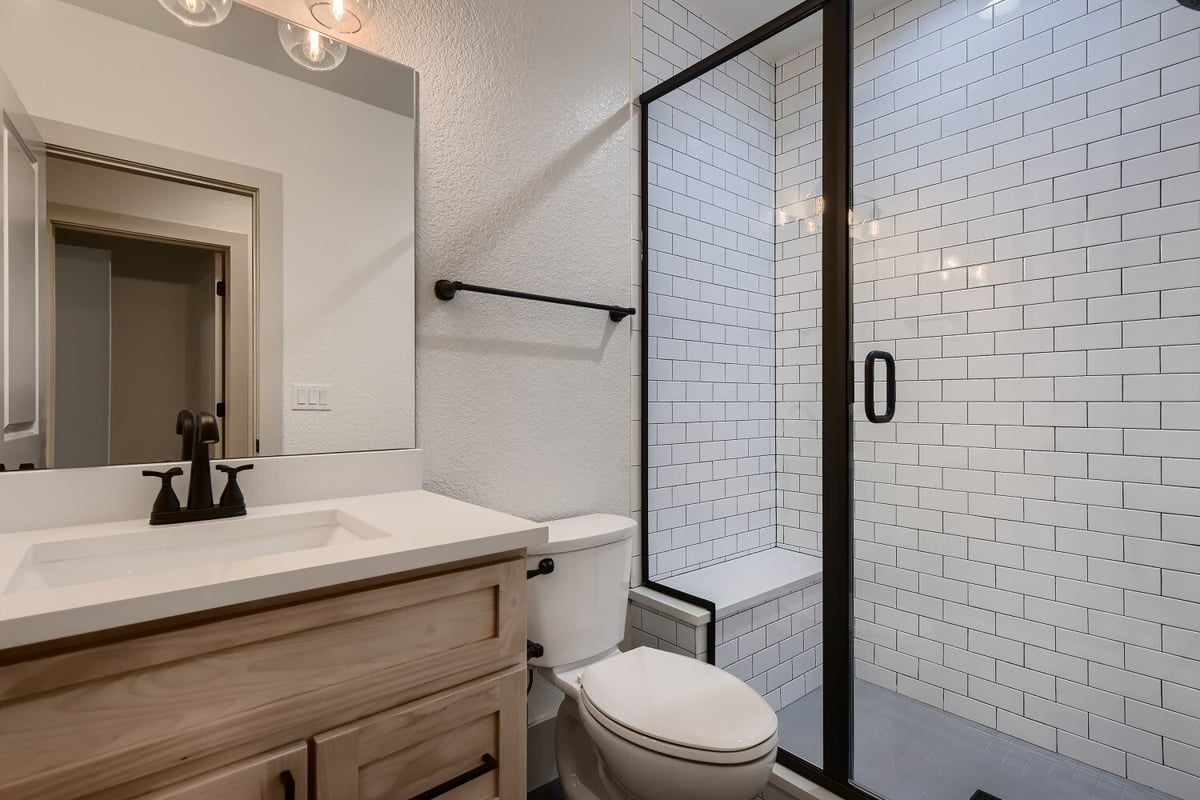 Bathroom with a single vanity, a toilet, and a glass-enclosed shower area in a Sheffield Homes home in Westminster, CO