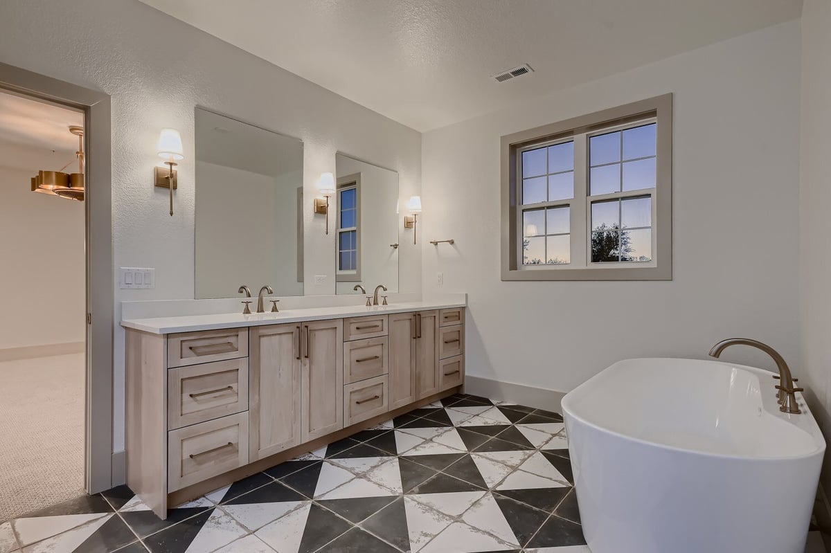 Bathroom with checkerboard flooring, a freestanding tub, and a large dual vanity in a Sheffield Homes home in Westminster, CO