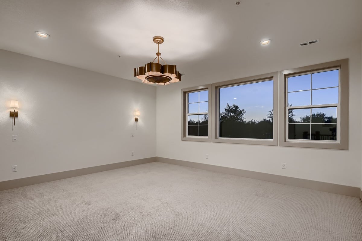 Bedroom with carpet flooring, featuring a beautiful chandelier and wall-mounted lamps by Sheffield Homes in Westminster, CO