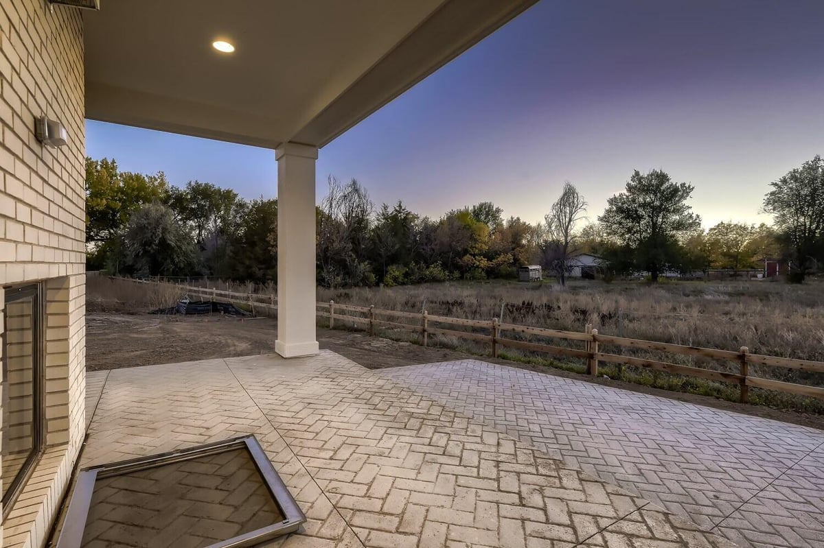 Custom patio with a diagonal brick design and a top hood supported by strong pillars, by Sheffield Homes in Westminster, CO