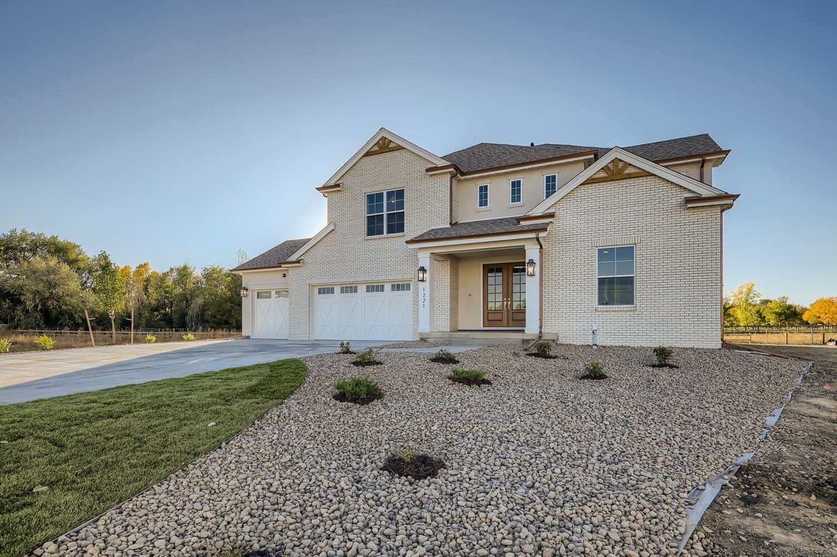 Daylight exterior front view of a custom home with a front yard lawn, built by Sheffield Homes in Westminster, CO