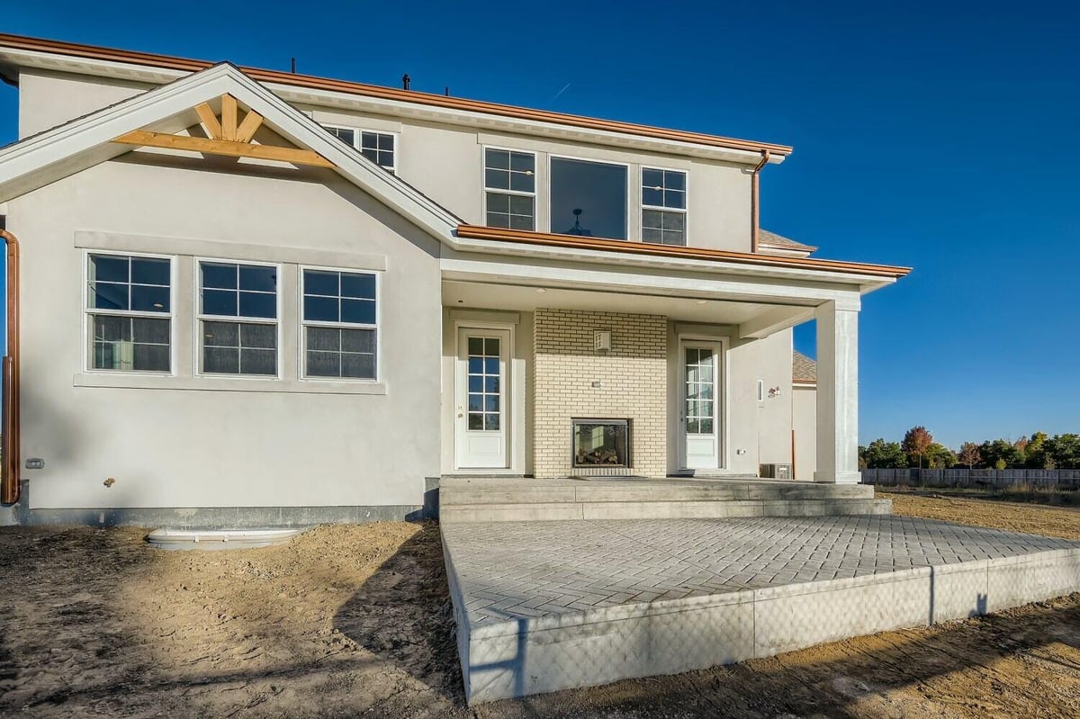 Daylight exterior rear view of a custom home featuring stone and wooden artwork, built by Sheffield Homes in Westminster, CO