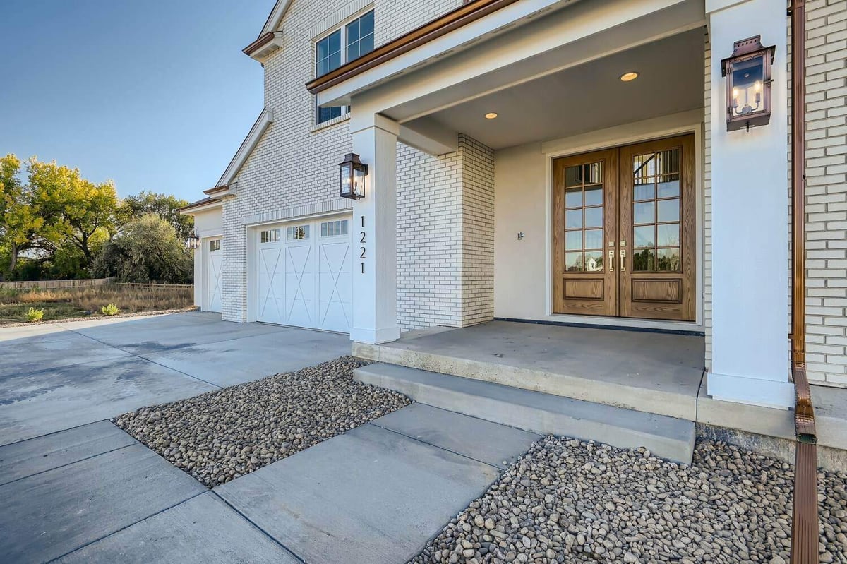 Exterior front entrance of a custom home with a paved pathway leading to the main door, by Sheffield Homes in Westminster, CO