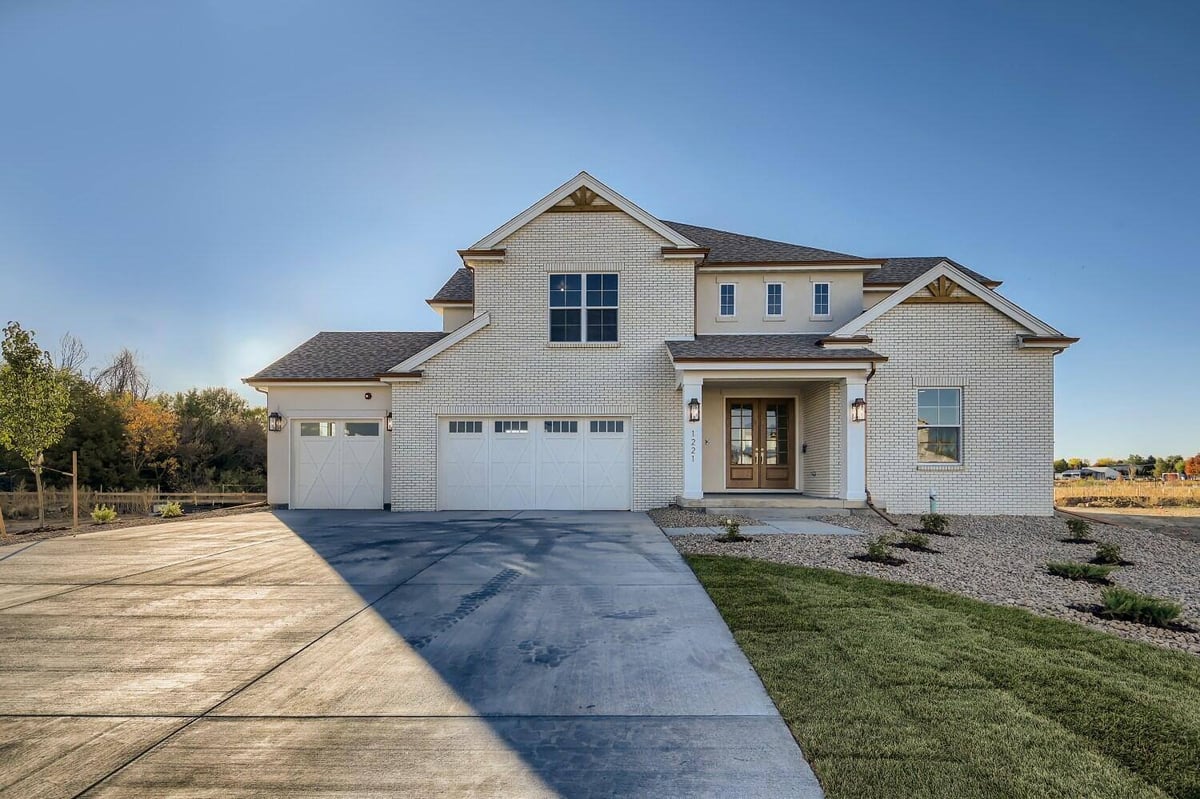 Exterior front of a custom home with an outdoor lawn and a paved driveway, Sheffield Homes in Westminster, CO