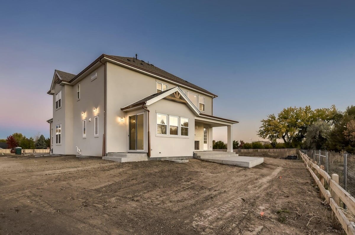 Exterior rear view of a custom home with a backyard and boundary fence in a Sheffield Homes home in Westminster, CO