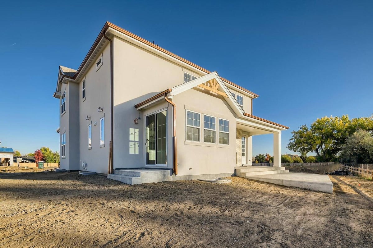 Exterior rear view of a custom home with a backyard enclosed by a boundary fence, by Sheffield Homes in Westminster, CO