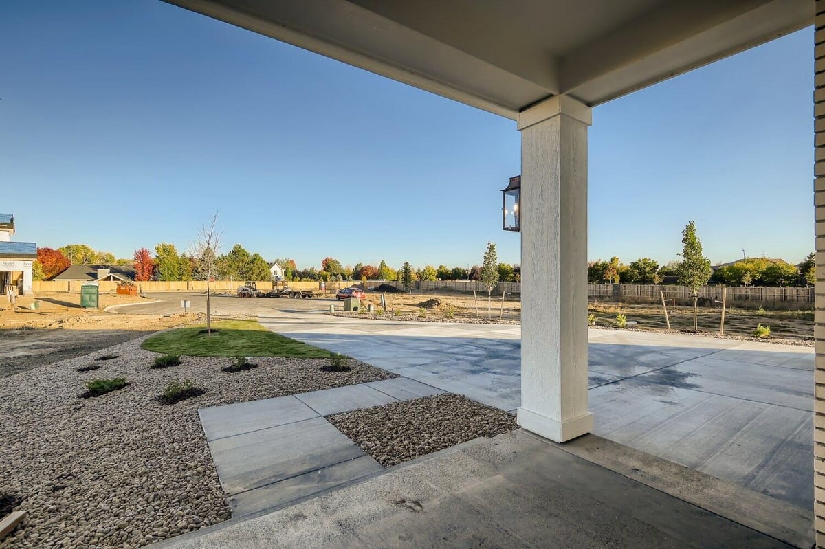 Front patio with views of the outdoor pebble and plant-covered lawn of a custom home by Sheffield Homes in Westminster, CO