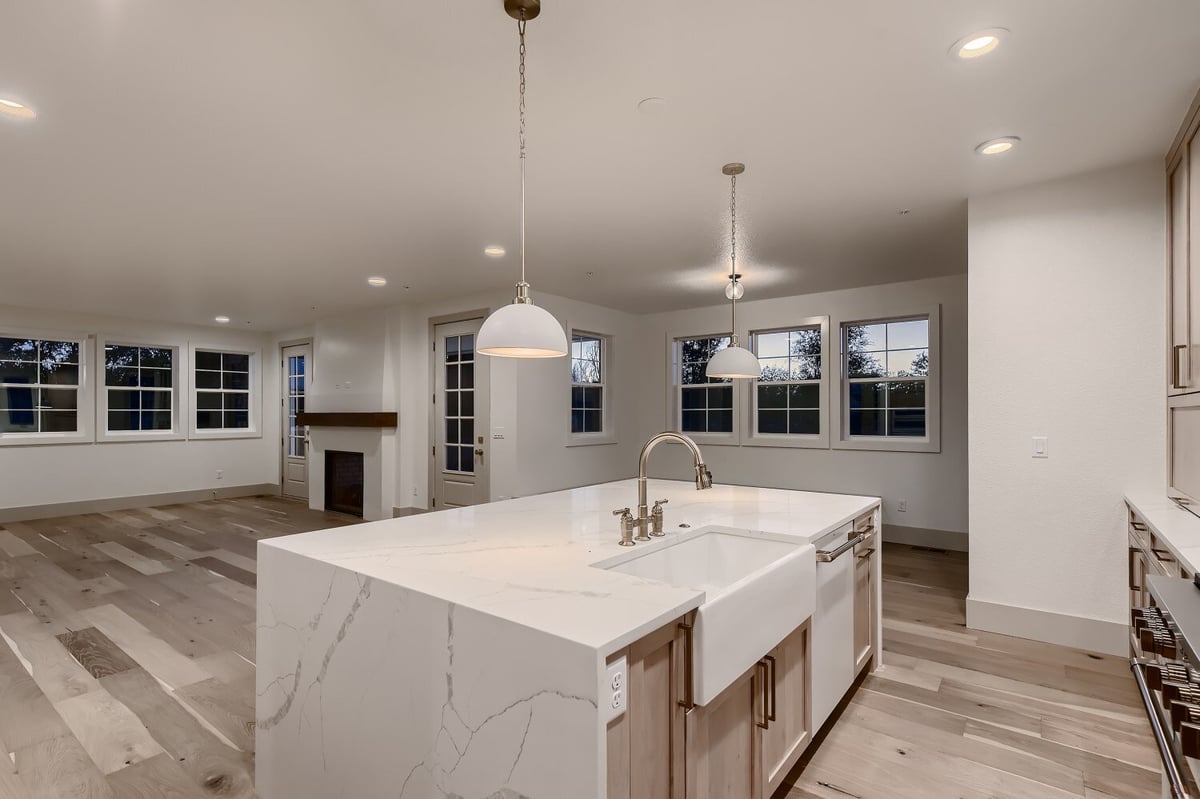 Kitchen island with a sleek granite countertop and base cabinets in a custom home by Sheffield Homes in Westminster, CO