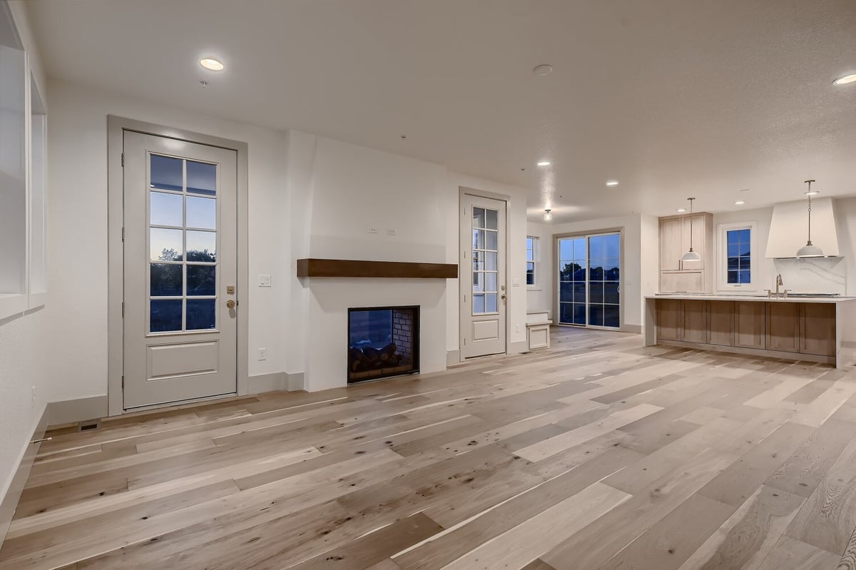 Living room with vinyl flooring, a wall-mounted fireplace, and a corner wetbar in a Sheffield Homes home in Westminster, CO