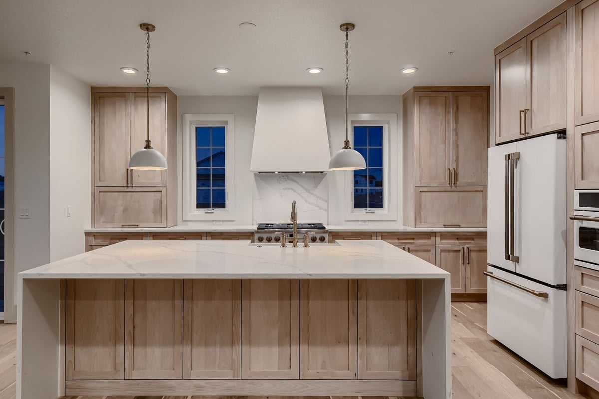 Modern kitchen featuring sleek cabinetry and elegant lighting in a custom home by Sheffield Homes in Westminster, CO