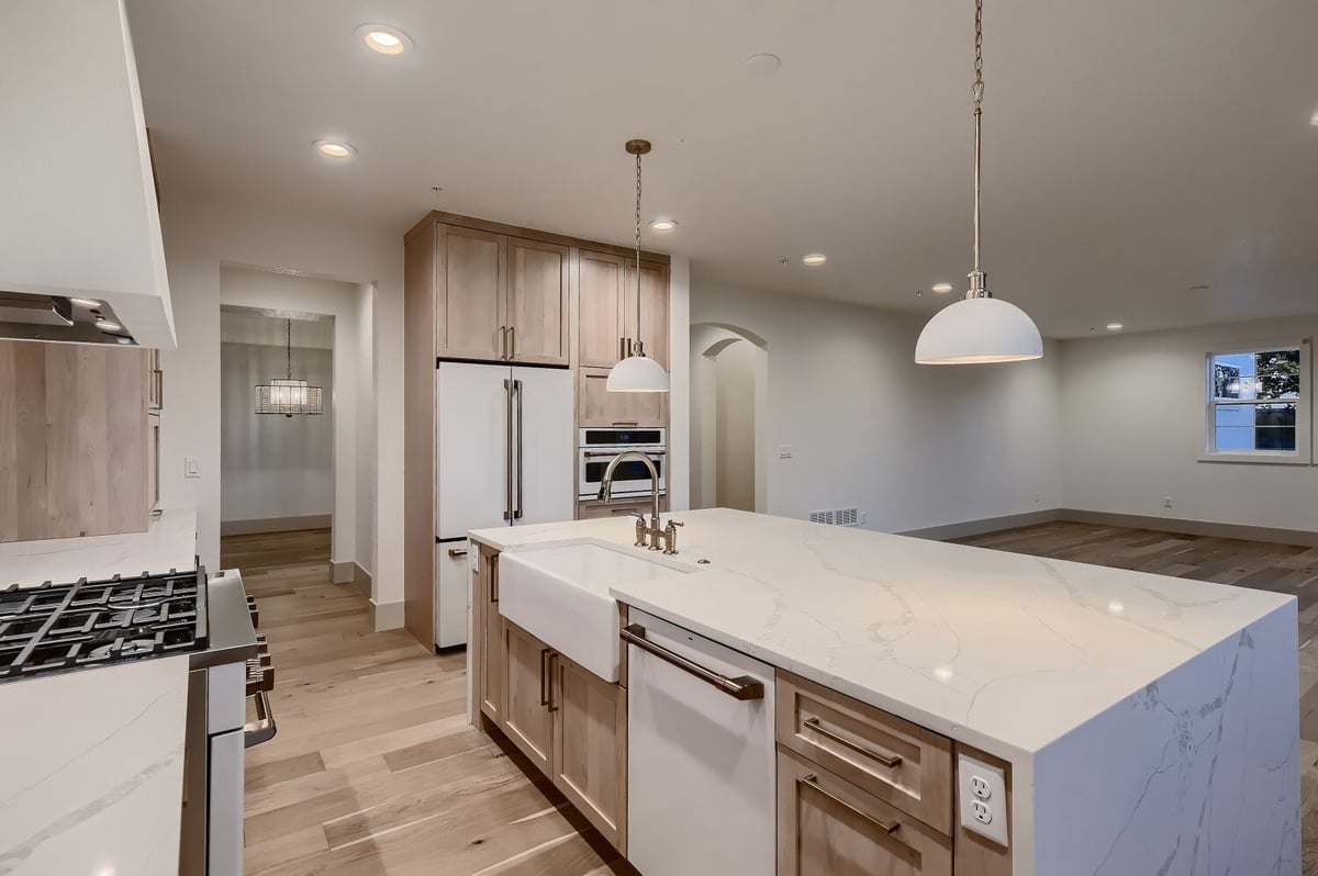 Modern open kitchen featuring a marble countertop island and stove fixtures in a Sheffield Homes home in Westminster, CO