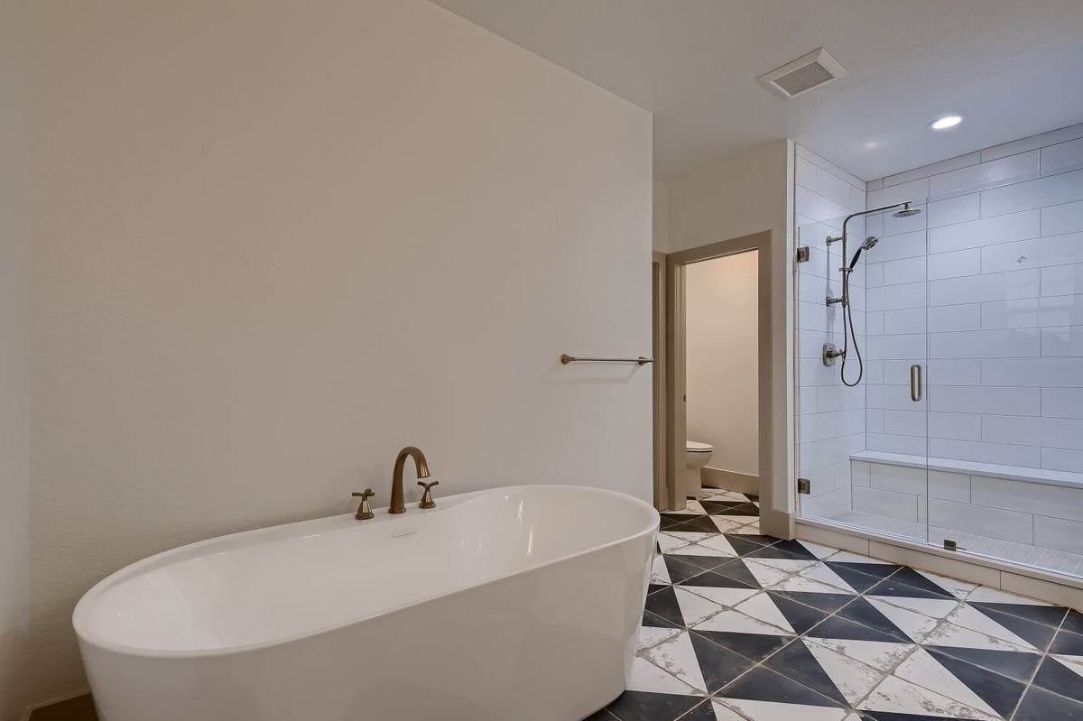 Second-floor bathroom with checkerboard flooring, a bathtub, and a shower room in a Sheffield Homes home in Westminster, CO