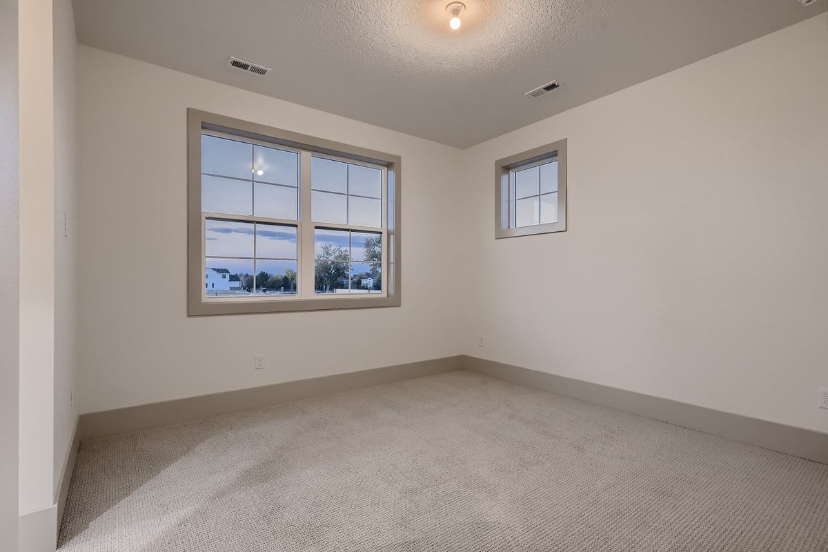 Second-floor bedroom with carpet flooring, a night light bulb, and sliding windows in a Sheffield Homes home, Westminster, CO