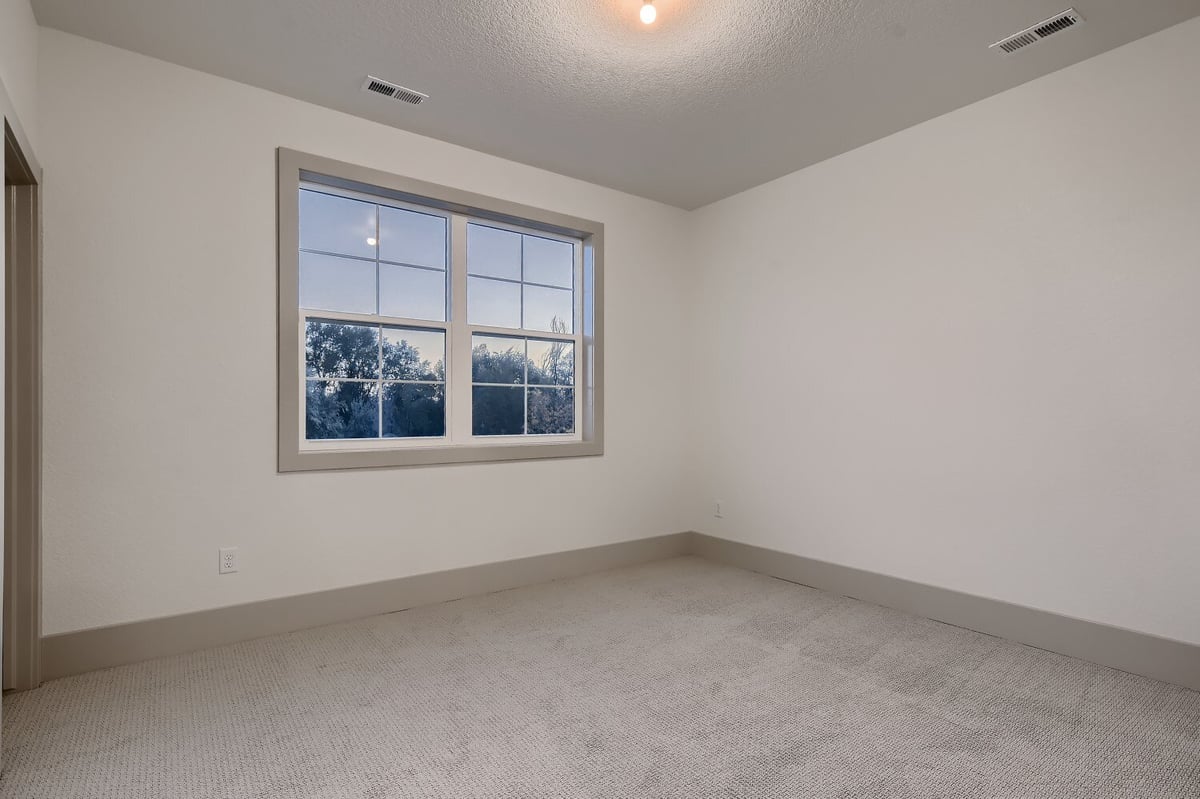 Second-floor bedroom with carpet flooring, a zero night bulb, and a sliding window in a Sheffield Homes home, Westminster, CO