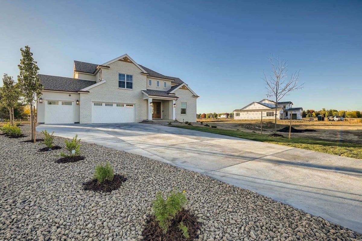 Side front view of a home with an outdoor lawn covered in pebbles and mini plants, by Sheffield Homes in Westminster, CO