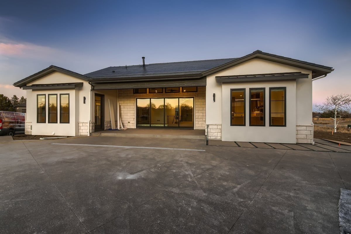 Backyard view of a custom home with minimal design and elegant lighting, built by Sheffield Homes in Westminster, CO