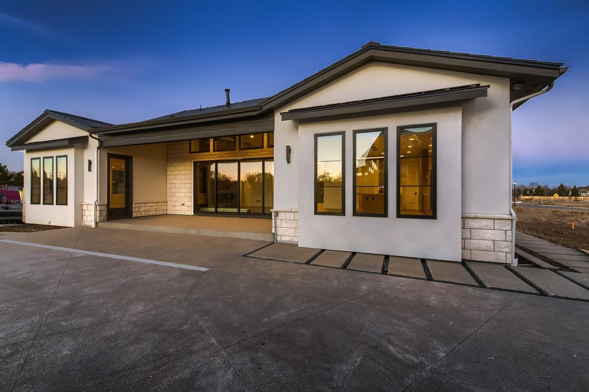 Backyard view of a custom home with minimal design and paved walkway outside, by Sheffield Homes in Westminster, CO