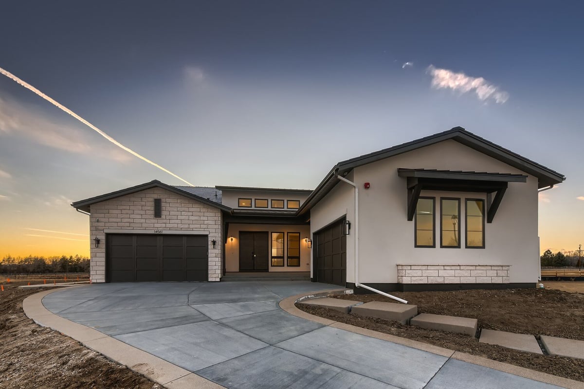 Exterior front of a custom home with a paved driveway and a front yard, by Sheffield Homes in Westminster, CO