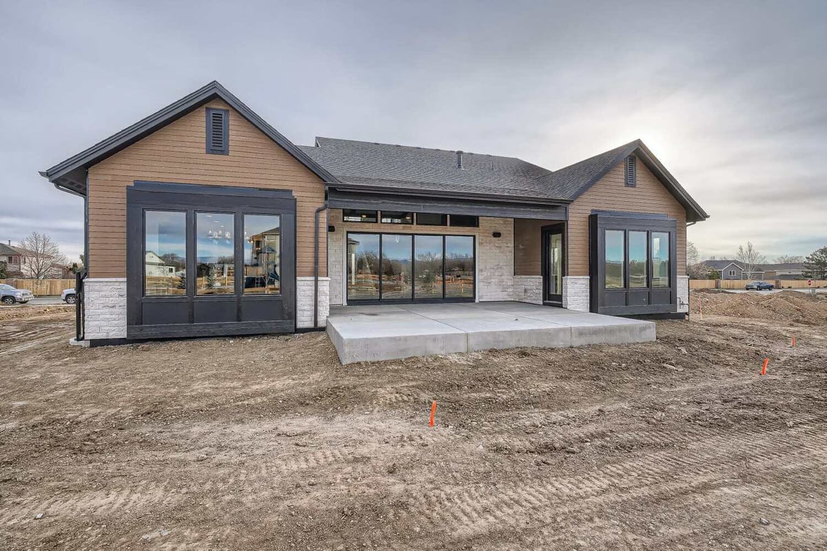 Daylight rear exterior view of a custom home featuring a patio and a backyard, built by Sheffield Homes in Westminster, CO