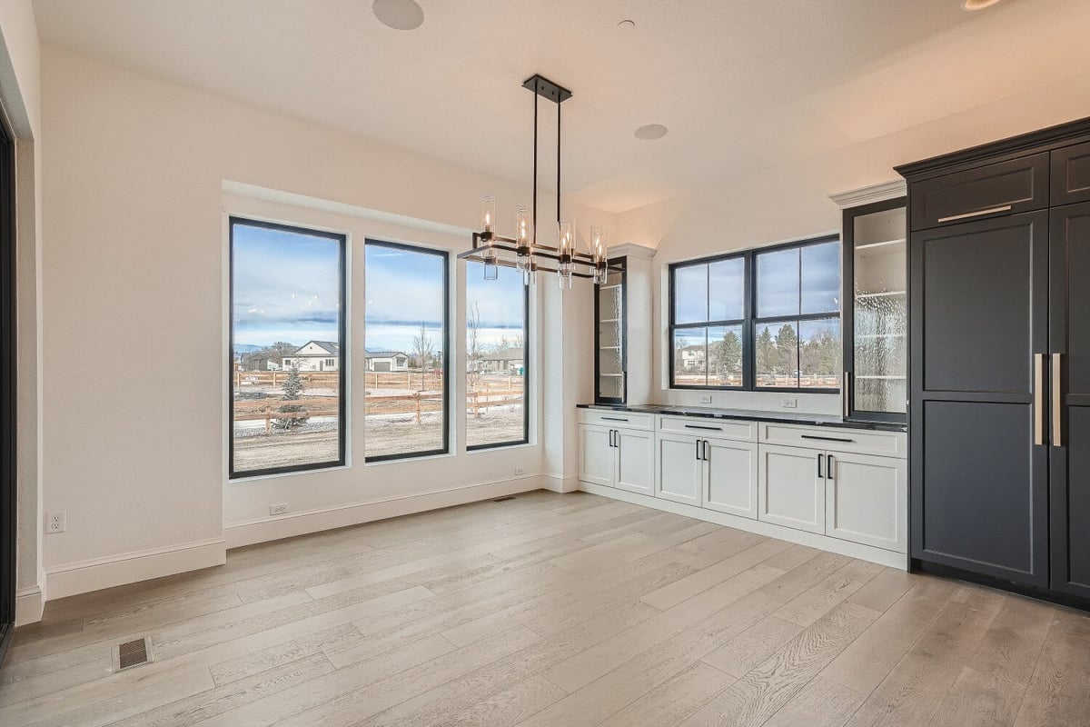 Dining room with a candle-lit pendant chandelier, sliding windows, and a wetbar, in a Sheffield Homes home in Westminster, CO