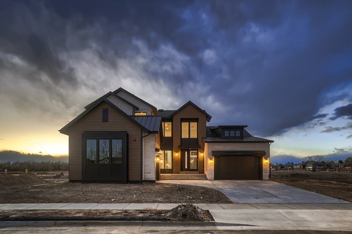 Exterior front view of a custom home featuring wooden artwork, a garage, and a driveway, by Sheffield Homes, Westminster, CO