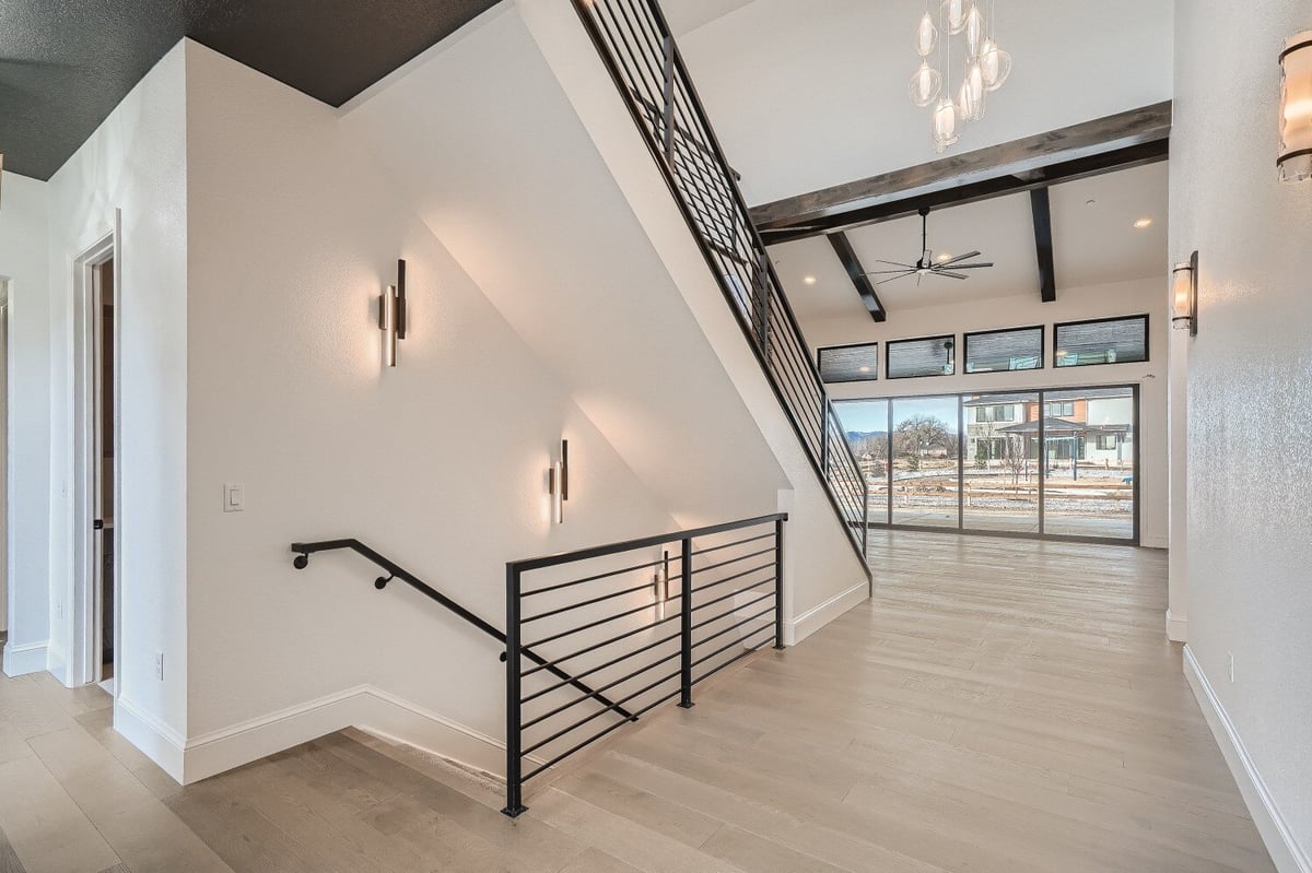 Foyer featuring staircases with metal railings and main sliding doors for outside views, by Sheffield Homes, Westminster, CO