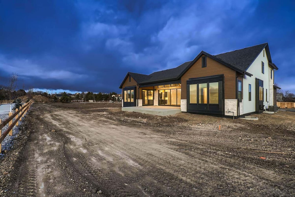 Large backyard with a boundary fence and the rear exterior of a custom home by Sheffield Homes in Westminster, CO