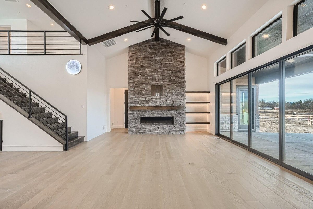 Living room with a front wall fireplace, and large sliding doors offering outside views by Sheffield Homes, Westminster, CO