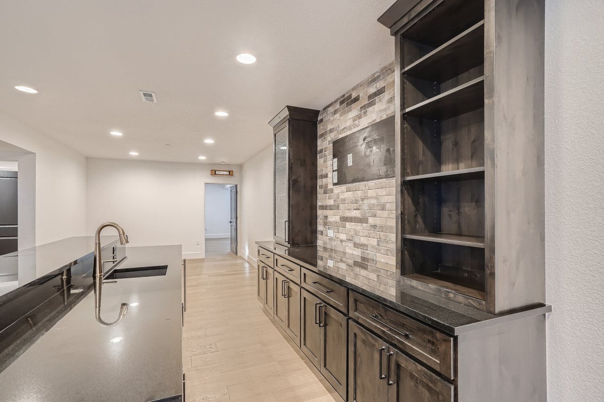 Lower level wetbar with a central counter and corner cabinets in a Sheffield Homes home in Westminster, CO